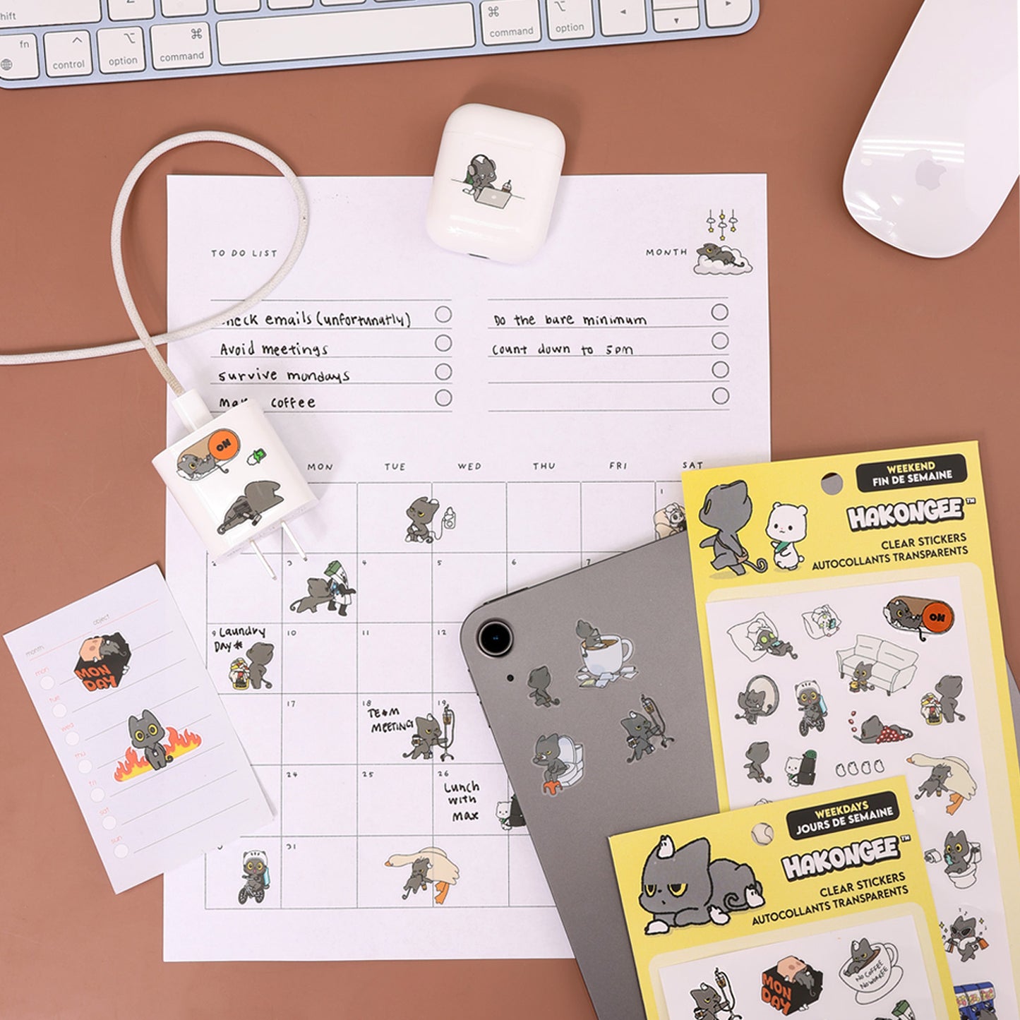 Hakongee clear stickers applied to a tablet, charger, and AirPods case with both sticker packs nearby