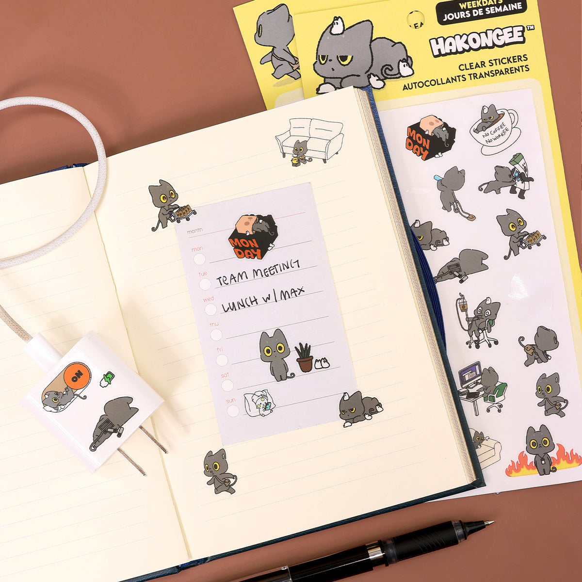 Hakongee weekday clear stickers applied inside a planner journal next to the unopened sticker sheet